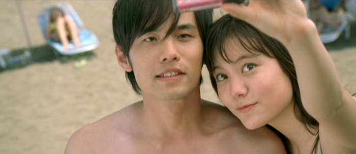 Takumi (Jay Chou) and Natsuki (Anne SUZUKI An) at the beach.